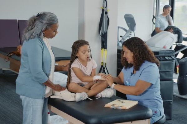 Child giggling even as using a brightly colored pediatric walker in the course of home remedy.